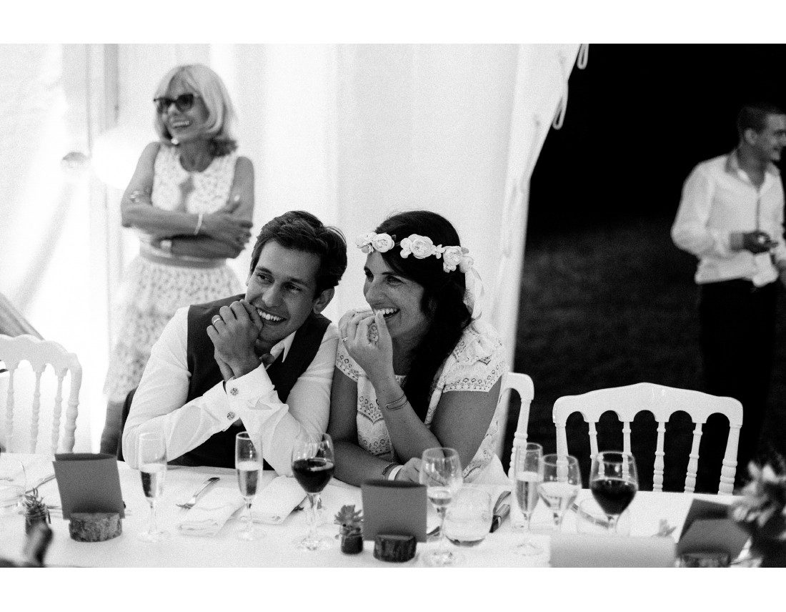 MAriés riant a un discours pendant leur mariage