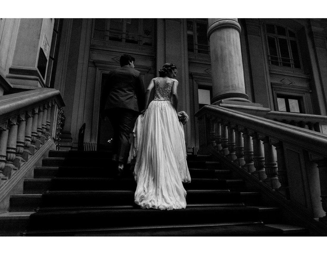 couple montant l'escalier d'honneur de la mairie du 10e arr de Paris.