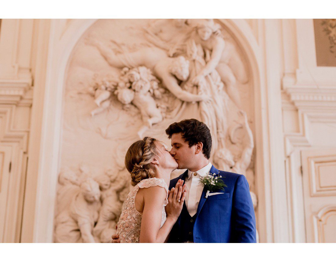 Couple qui s'embrassse pendant leur mariage a la mairie du 10e à Paris.