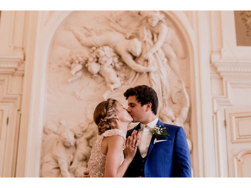 Couple qui s'embrassse pendant leur mariage a la mairie du 10e à Paris.