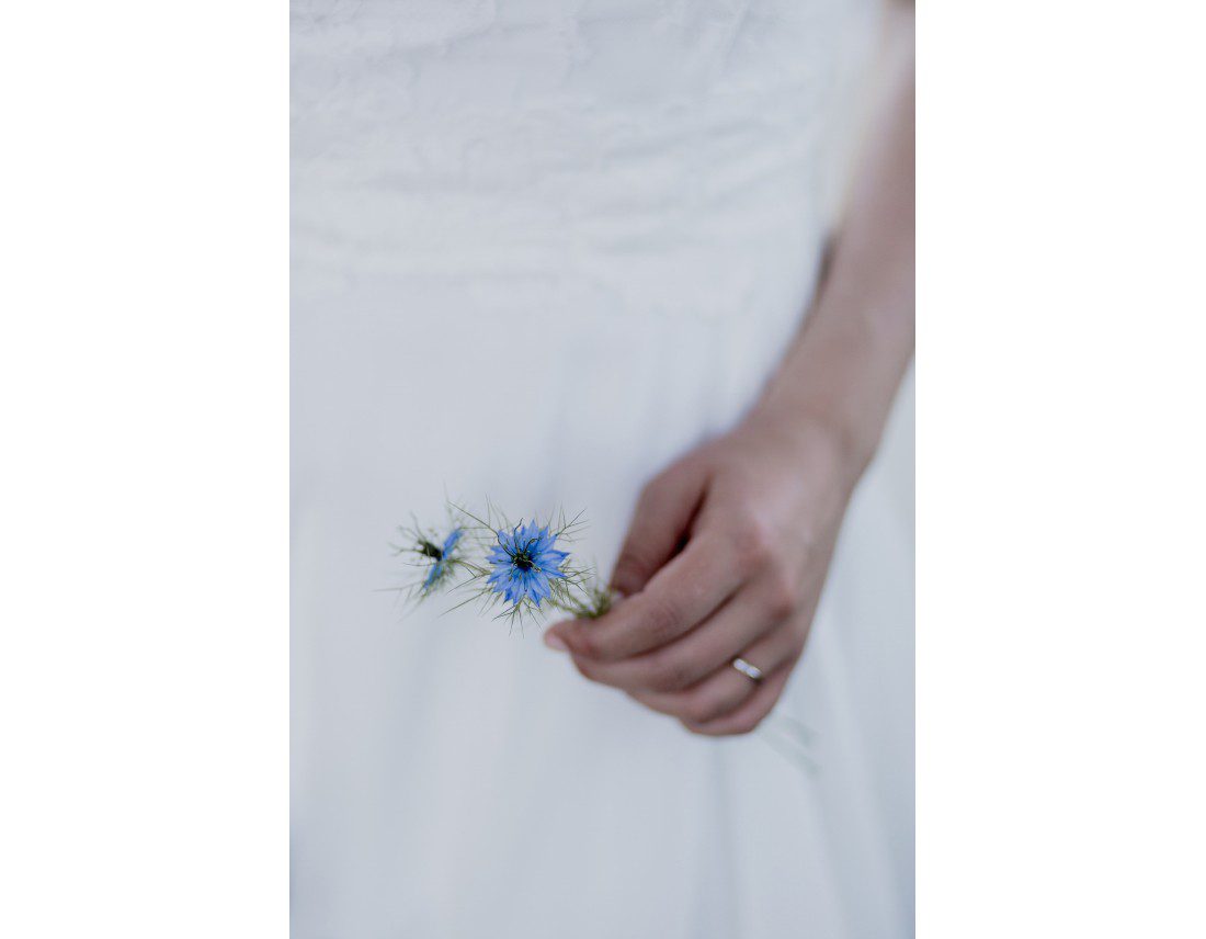 Fleur de nigelle dans la main d'une mariée.