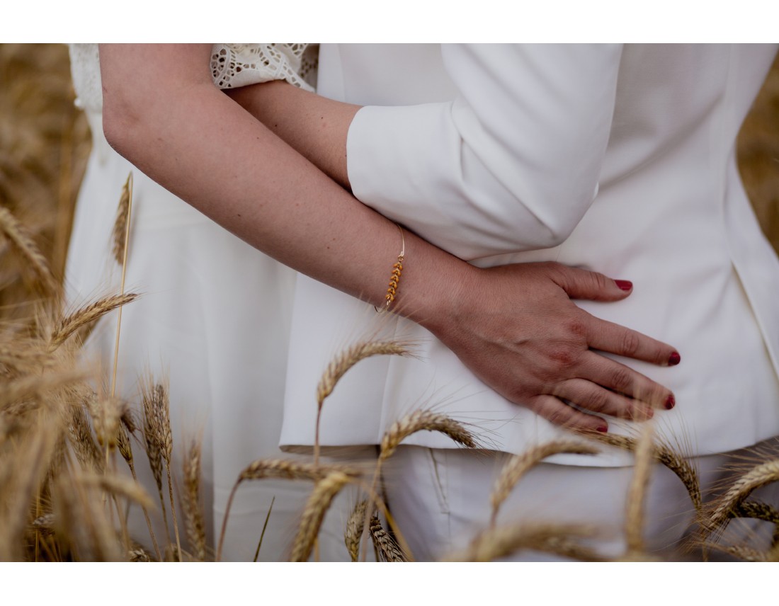 Mains de couple de femmes dans champ de blé, mariage lesbien