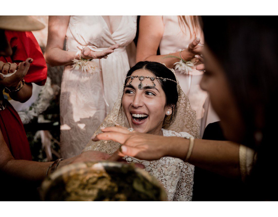 Mariée riant pendant la ceremonie du hénné.